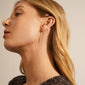 TAHOE chain earrings in hematite color, featuring a versatile half rod, half chain design, worn by a woman with long blonde hair.