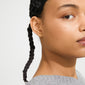 Close-up of a person wearing AVA star earrings gold-plated, showcasing the small, satin-matt finish stud on their ear, alongside a light gray knitted sweater.