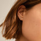 Close-up of a woman's ear adorned with Pilgrim's silver-plated MOLLY earrings, showcasing minimalist Scandinavian style and elegance.