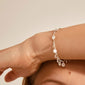 Silver-plated CAROL bracelet featuring mini-coins and crystals on a woman's wrist, capturing Pilgrim's blend of timeless and trendy Danish design.
