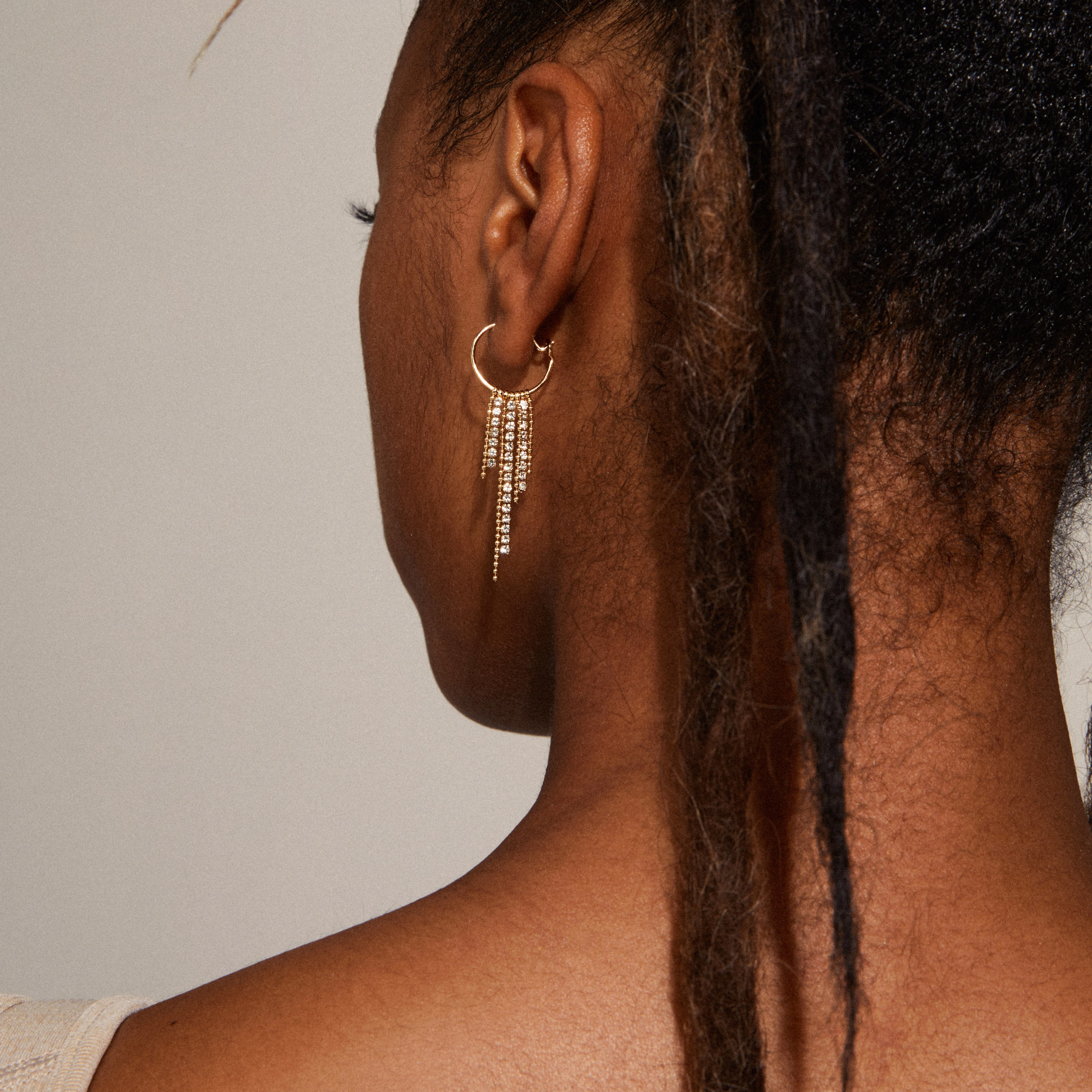 Maja crystal waterfall hoop earrings, gold-plated, featuring an asymmetrical pendant with Preciosa crystals and round ball-chains for a stylish, lively expression.