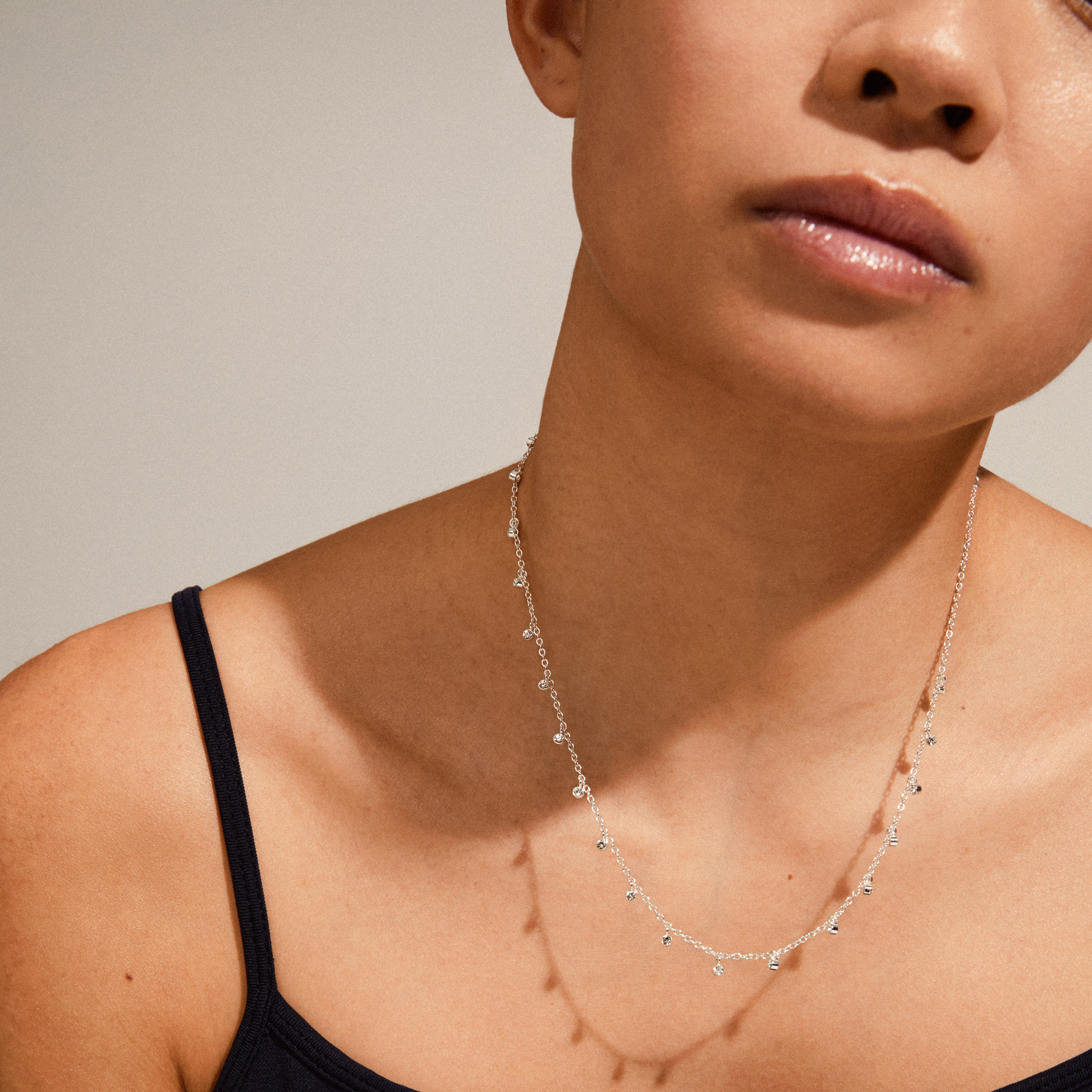 MAJA crystal multi drops necklace silver-plated on a woman's neck, showcasing delicate curb chain and crystal charms. Ideal for personalized style layering.