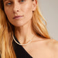 BERTHE pearl necklace gold-plated, elegantly worn by a woman, showcases unique freshwater pearls with playful shapes, embodying a classic and natural design.