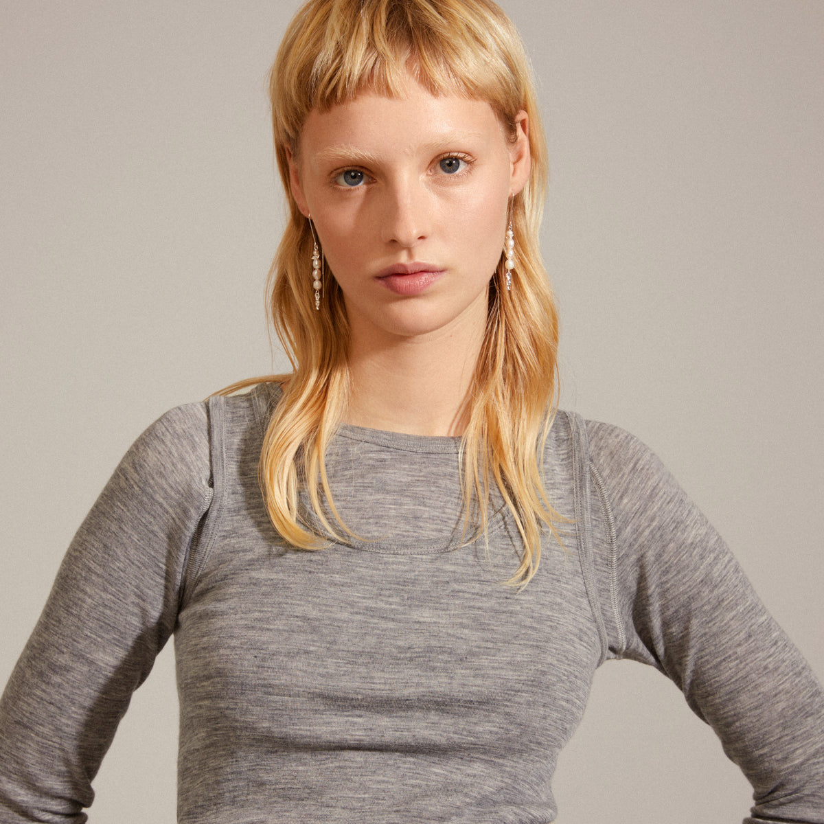 Woman wearing BERTHE pearl chain earrings, silver-plated, featuring genuine freshwater pearls and organic silver-plated details, exemplifying Pilgrim's blend of classic design and natural elegance.