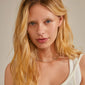 ROWAN necklace, 2-in-1, gold-plated, featuring sparkling crystals and delicate cable chains, worn by a woman with blonde hair, showcasing its elegance and layering style.
