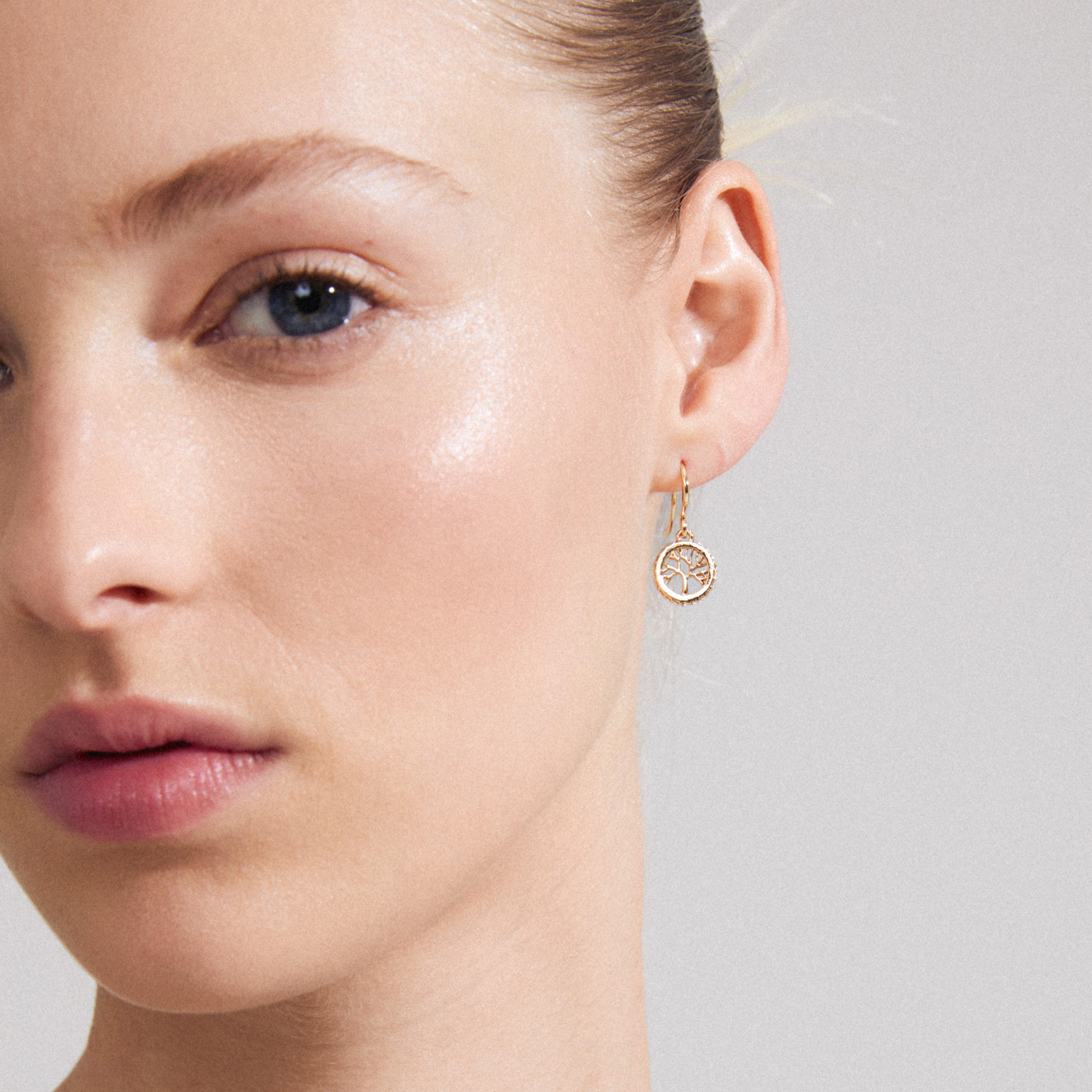 Gold-plated ALIA earrings with circular pendants featuring Preciosa crystals and Tree of Life carvings, symbolizing longevity and strength.