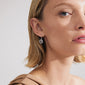 Silver-plated ALIA earrings featuring circular pendants with Preciosa crystals and Tree of Life carvings, worn by a woman with blonde hair.