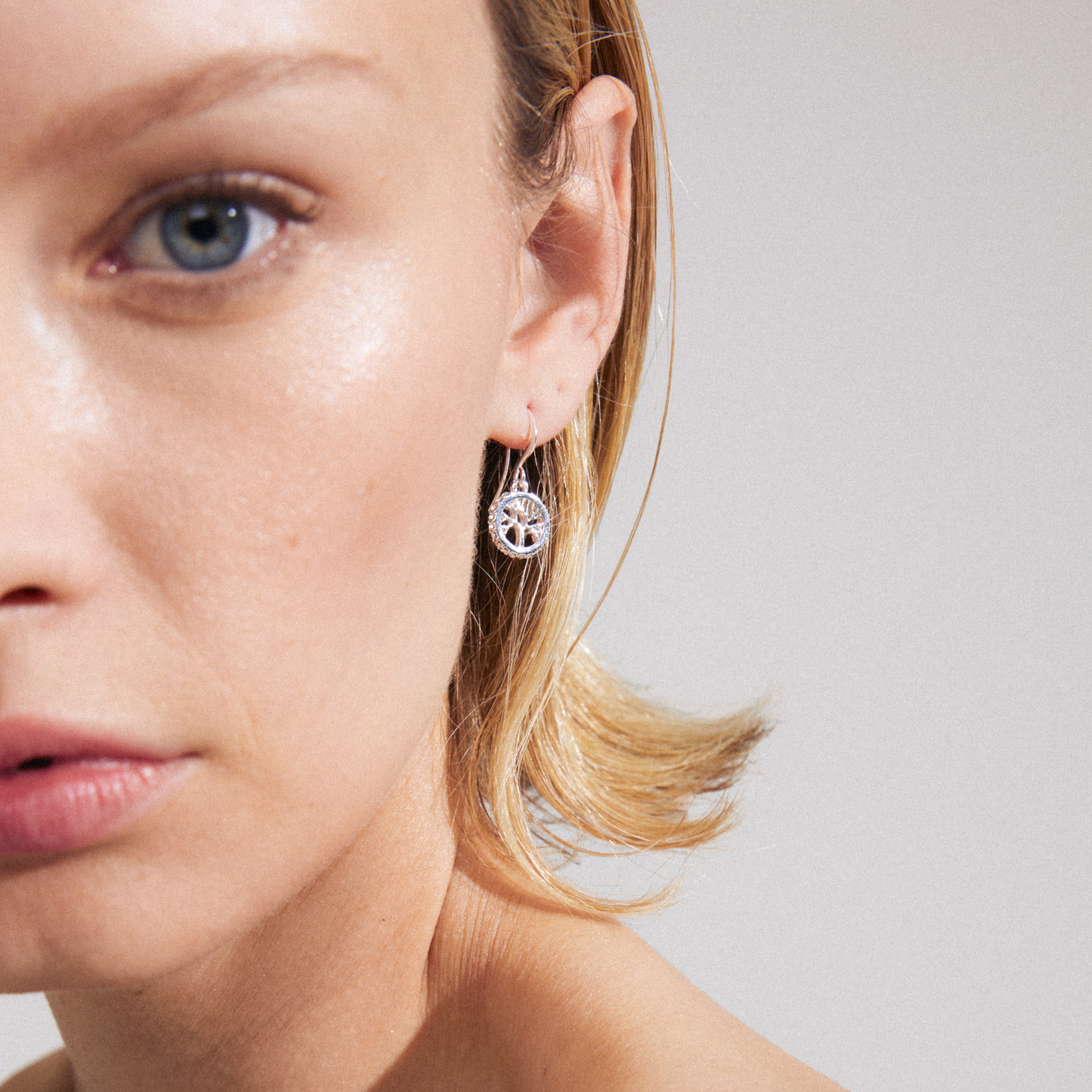 Silver-plated ALIA earrings featuring small circular pendants with Preciosa crystals and Tree of Life carvings, reflecting timeless elegance and symbolic connection.