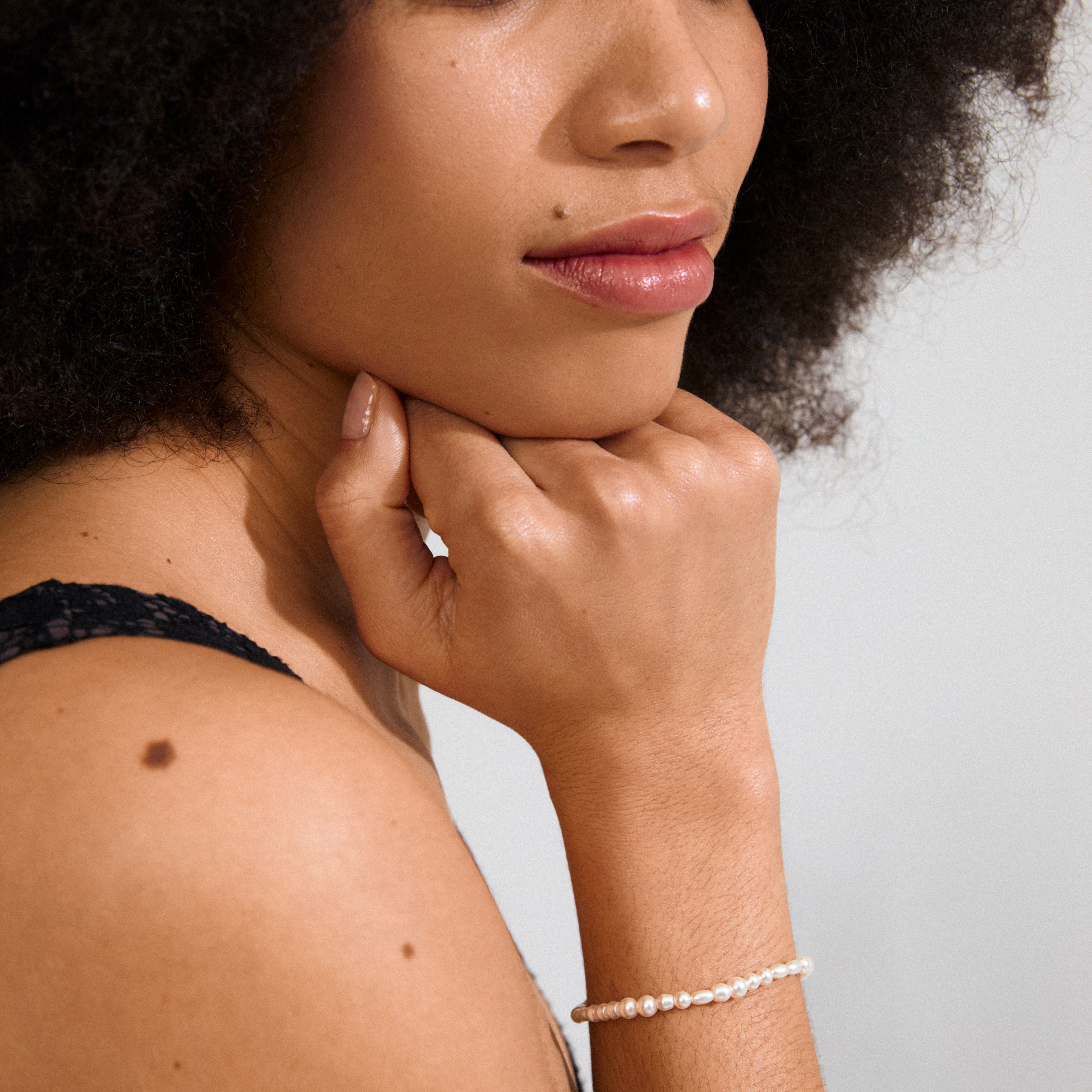 ELLIANA bracelet silver-plated featuring genuine freshwater pearls and mother-of-pearl glass beads, worn by a woman, highlighting its classic elegance and adjustable silver-plated extension.