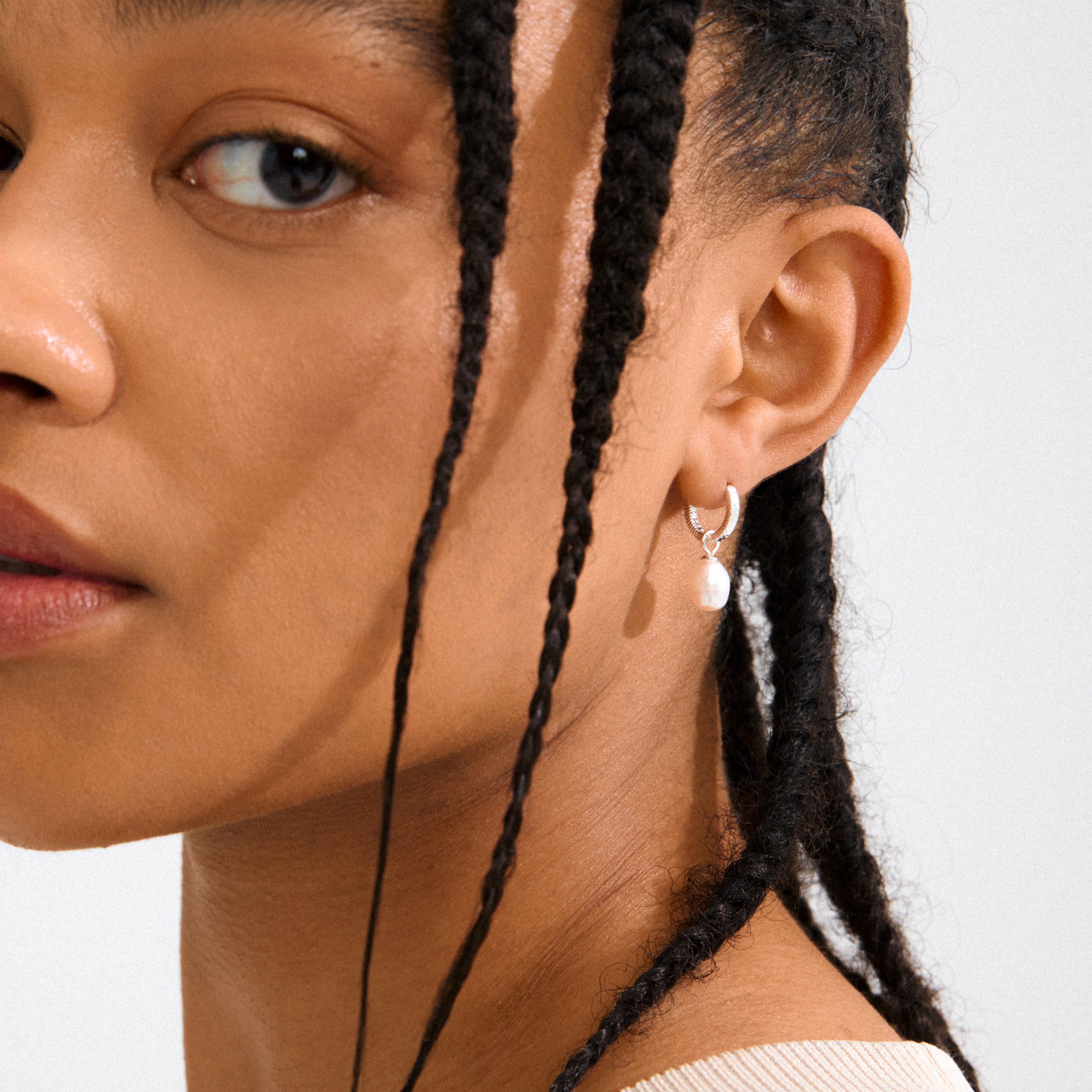 ELLIANA earrings silver-plated feature braided hoops with freshwater pearls, offering effortless elegance and versatility, perfect for pairing with seasonal chunky knits and soft hues.