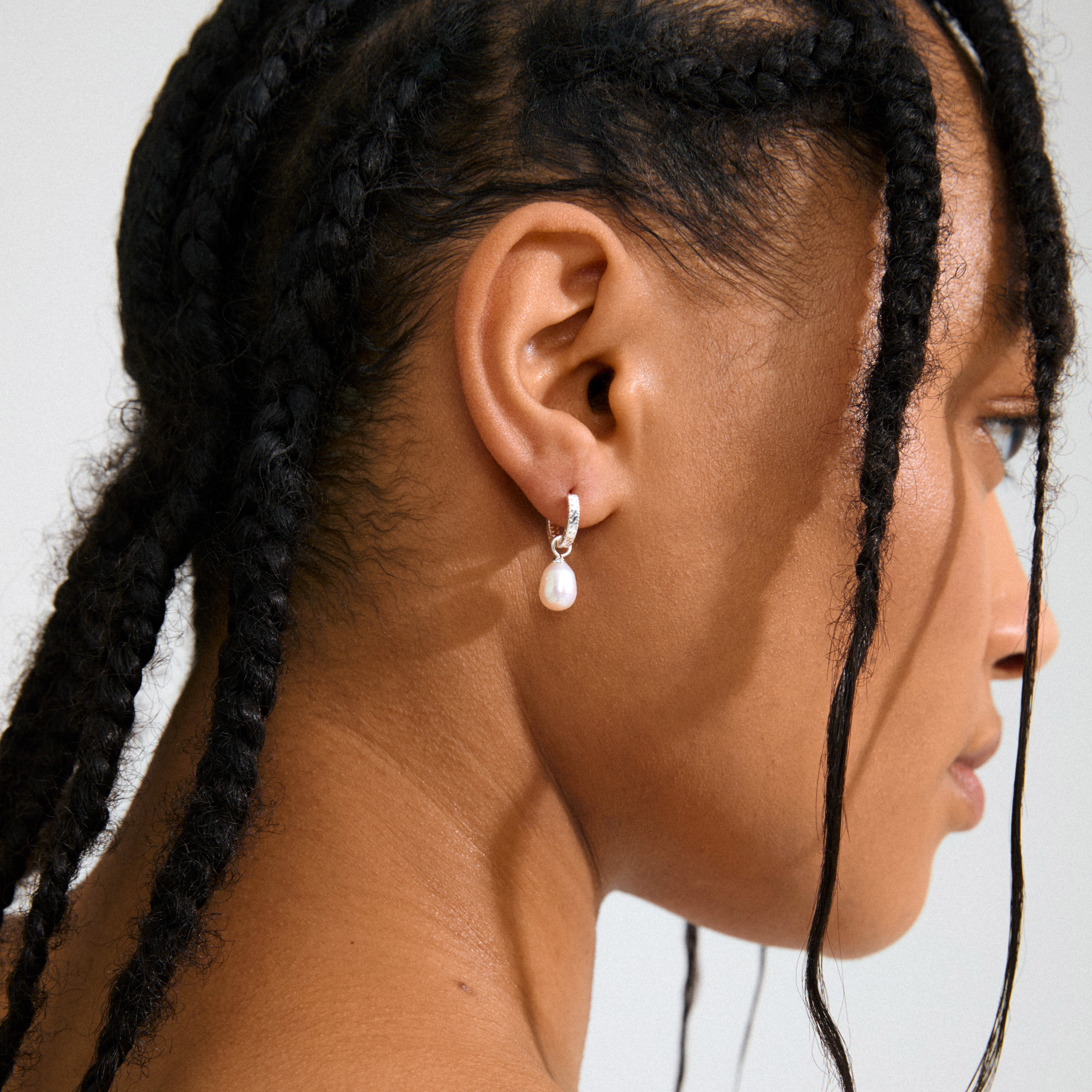 ELLIANA earrings, silver-plated hoops with braided texture and freshwater pearls, featuring easy click clasps for versatile styling with or without pendants.