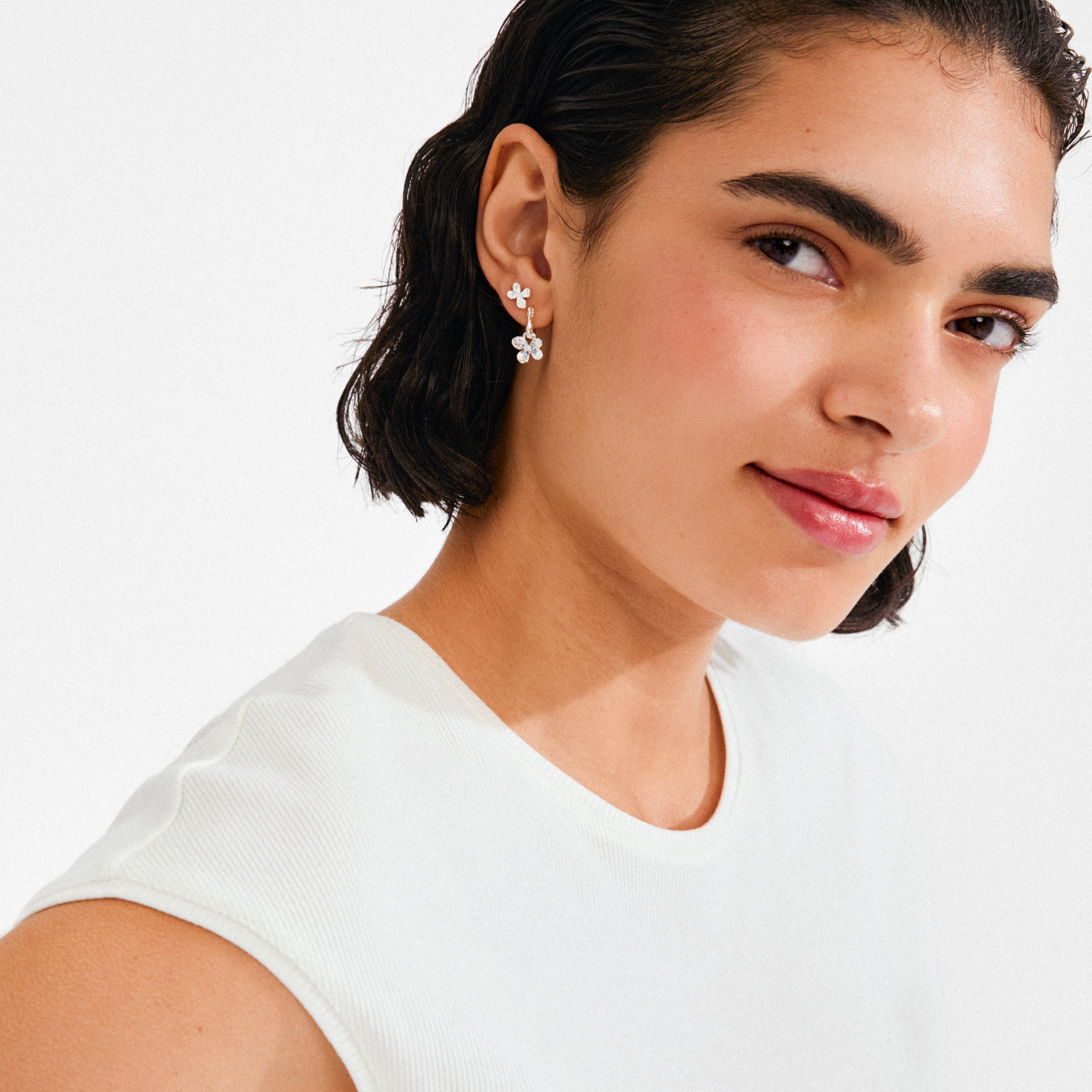 Young woman wearing Pilgrim's AJANI earrings 2-in-1 set, featuring delicate silver-plated flower drop earrings, highlighting minimalist beauty and versatile style.