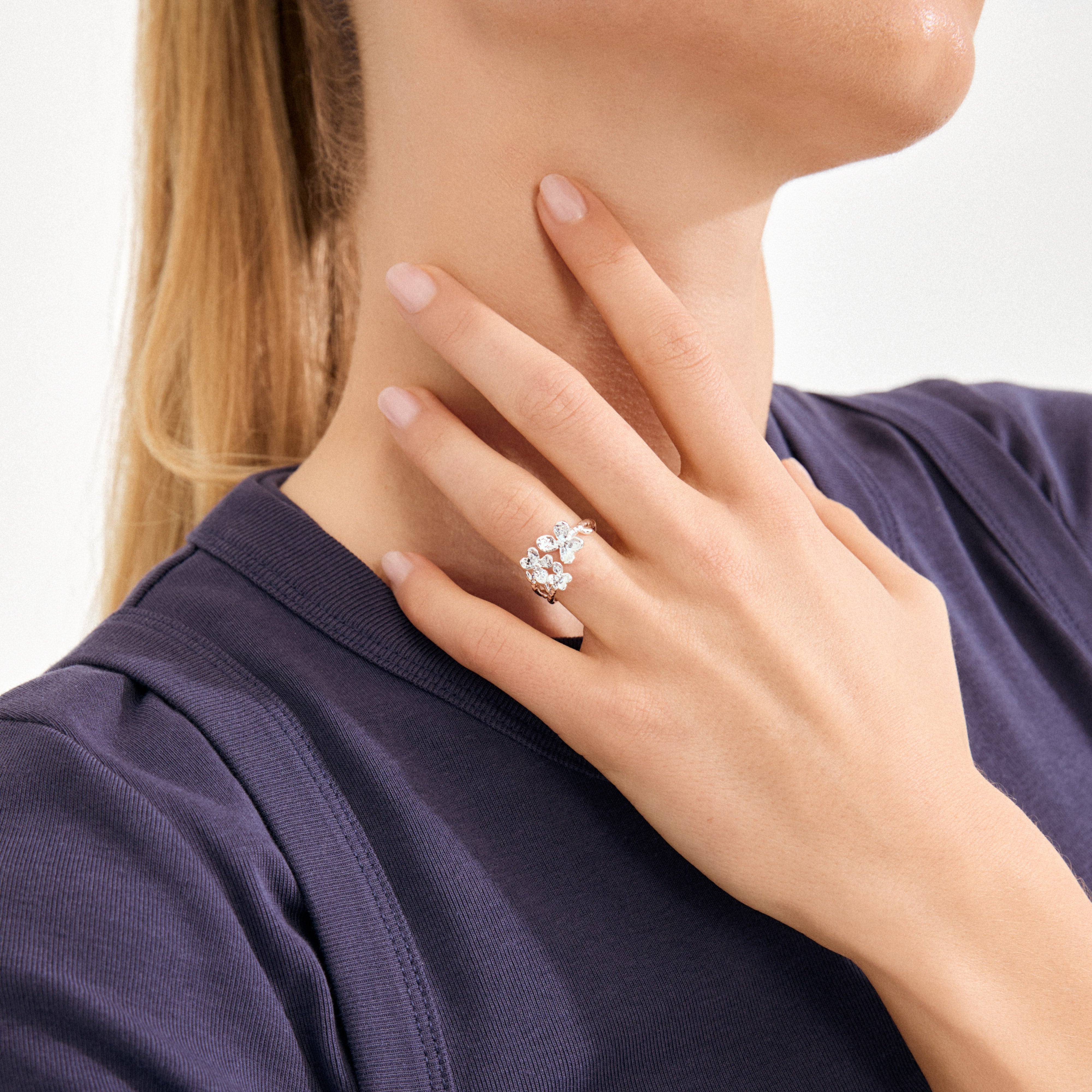 Woman's hand wearing a silver-plated AJANI ring with petal-shaped gems, reflecting Pilgrim's handcrafted, nature-inspired style. The ring is adjustable and water-resistant.