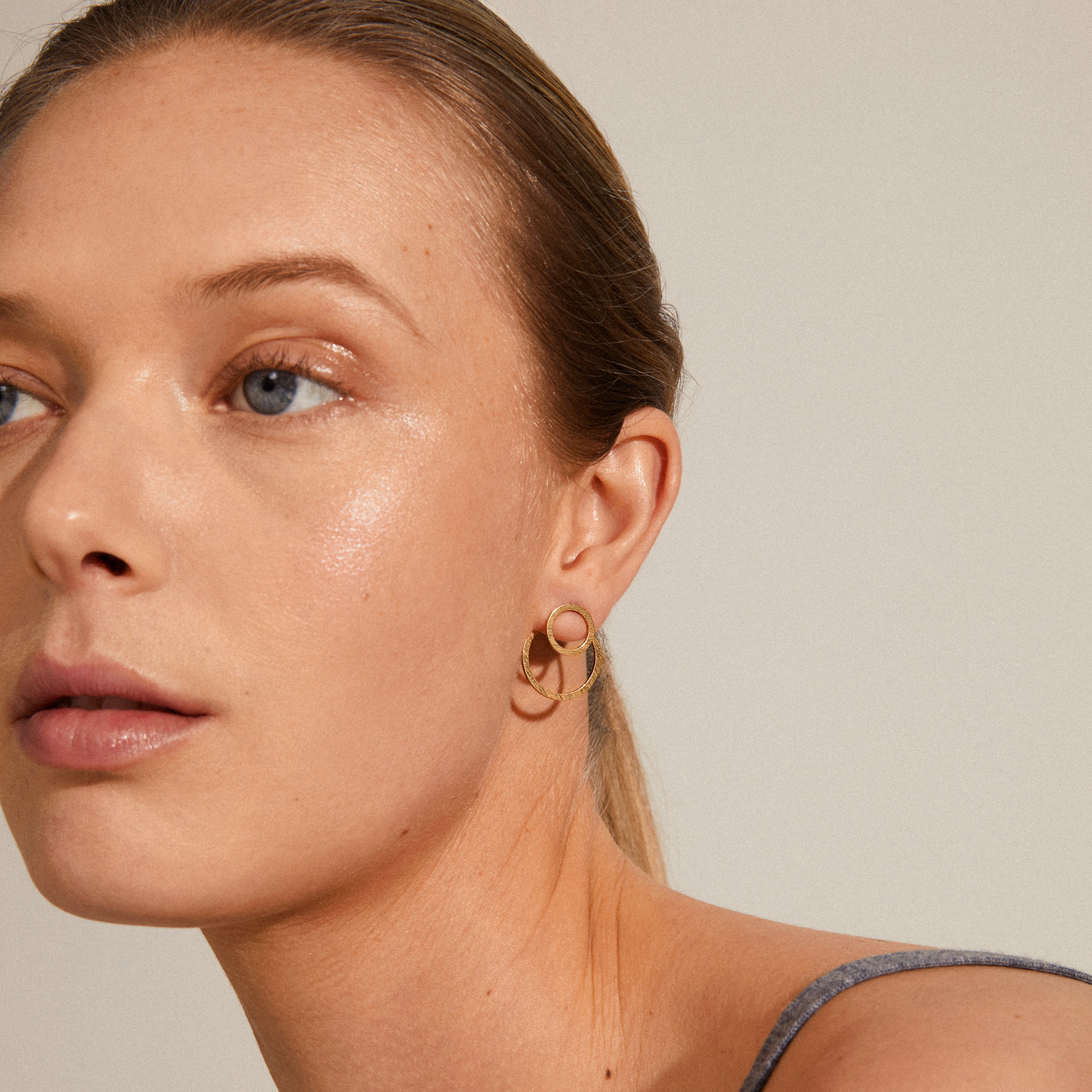 ZOOEY 2-in-1 gold-plated earrings feature a stylish 3D design with a rustic embossed pattern, showcasing a large circle behind and a small circle in front.