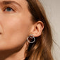 ZOOEY 2-in-1 earrings in hematite color, showcasing a 3D effect with the large circle behind and small circle front on the earlobe.