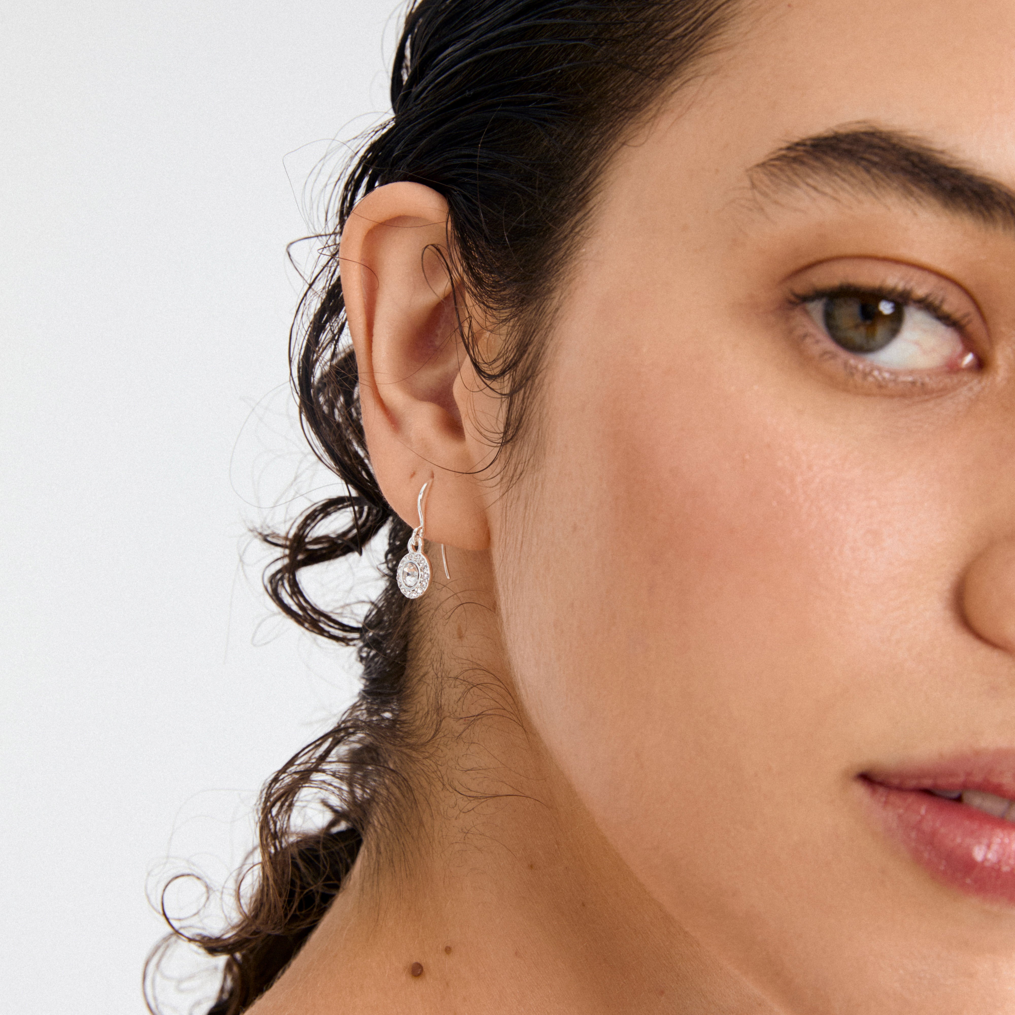 CLEMENTINE crystal earrings silver-plated, featuring a central Preciosa crystal surrounded by sparkling stones, elegantly displayed on a person with dark hair and minimal makeup.