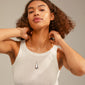 Woman wearing ALMA necklace; silver-plated, adjustable teardrop pendant with mirror and satin finishes, complementing her white tank top and curly hair.