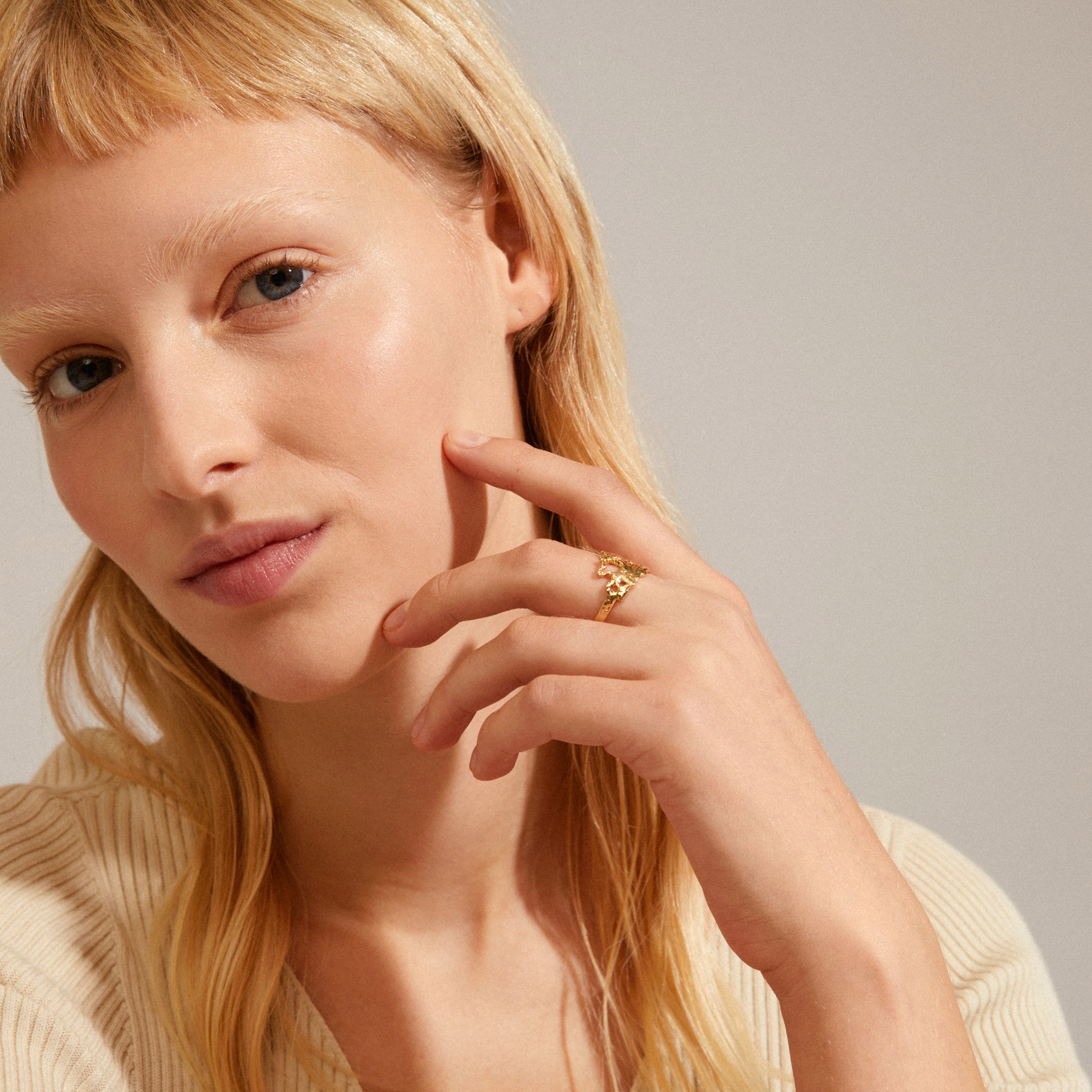 Close-up of a woman wearing the gold-plated BRENDA ring, showcasing its organic, jagged design. Perfect for adding a unique, handcrafted touch to any outfit.
