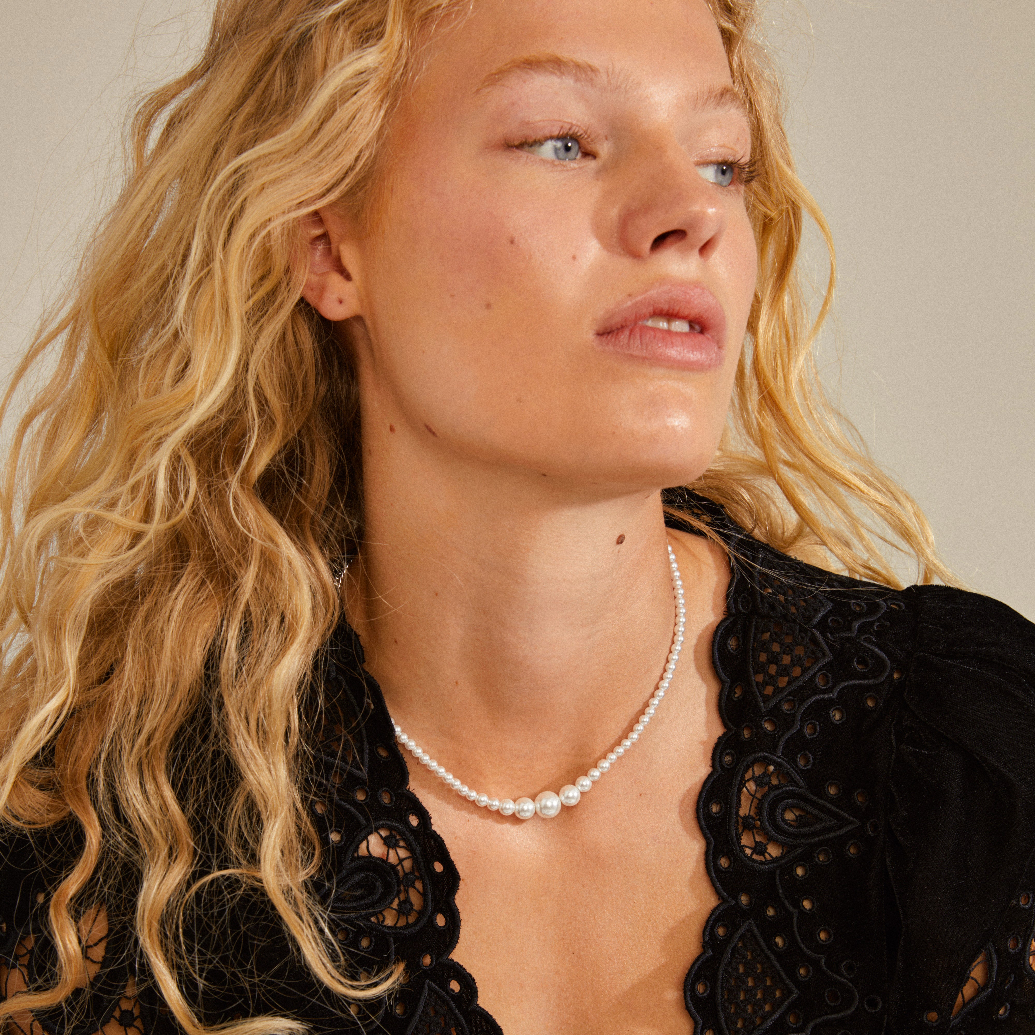 RELANDO pearl necklace silver-plated on a woman, featuring white glass pearls and a chunky curb chain, embodying elegance and urban style.