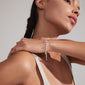 Woman wearing the PRUCENCE silver-plated bracelet featuring diverse charms, including hearts and moons, symbolizing love and dreams.