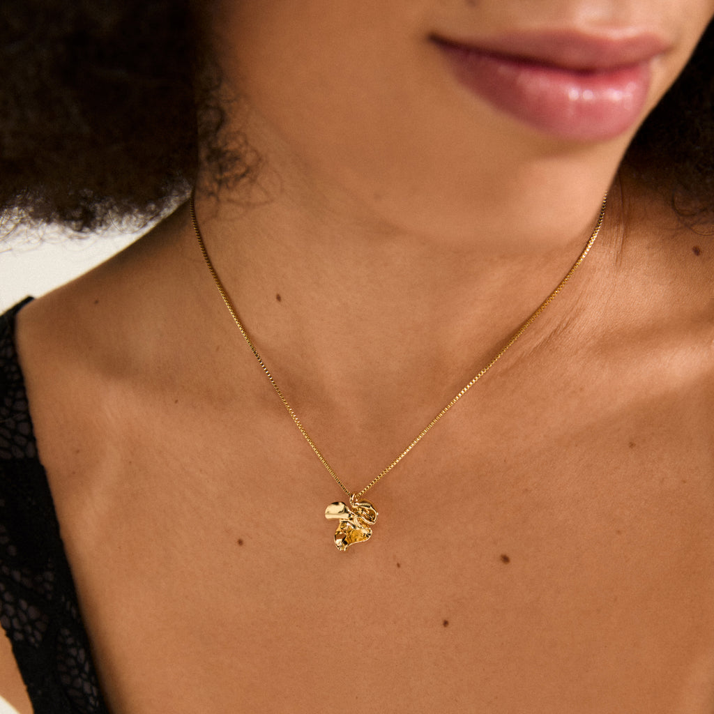 LUIS necklace gold-plated by Pilgrim features a sleek box chain with an abstract flower pendant, adaptable length for minimalist or layered styles.