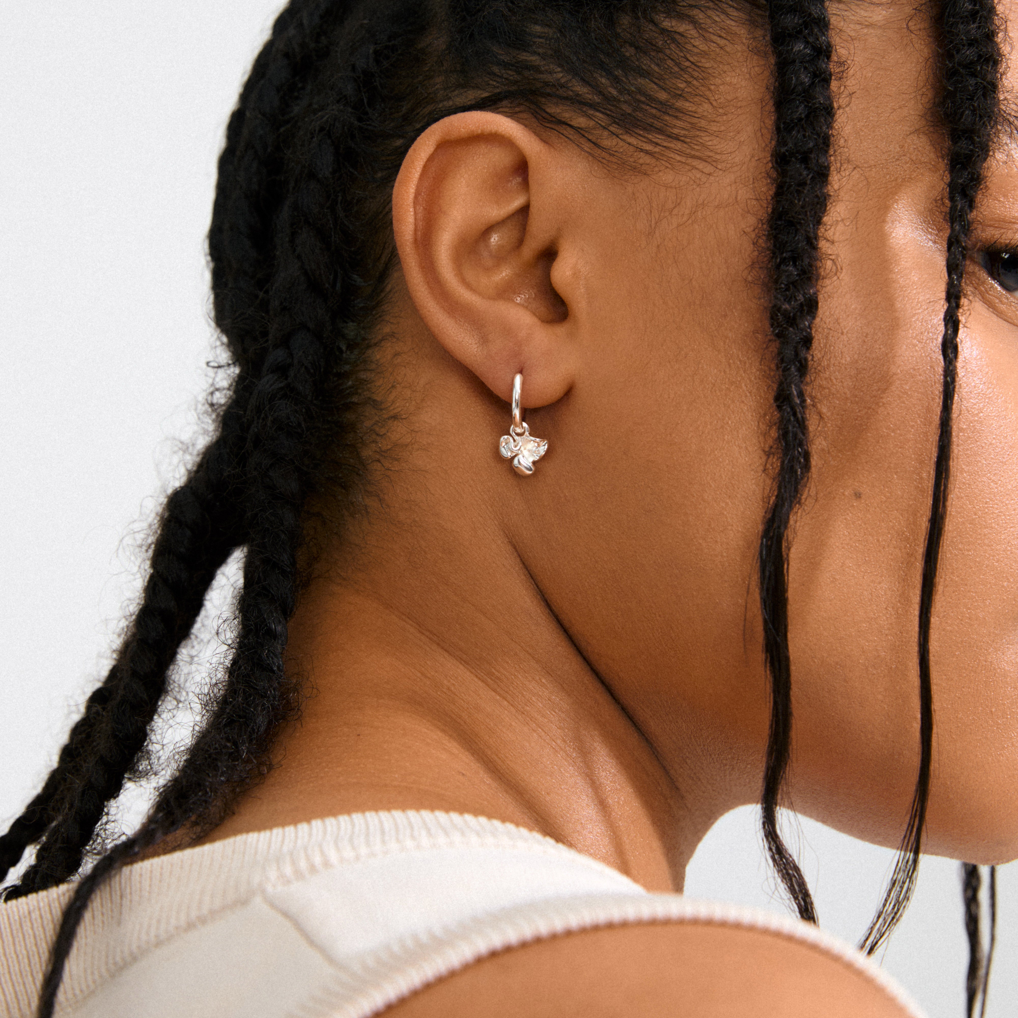 LUIS silver-plated earrings with abstract flower pendants, offering versatile styling options for a boho or minimalist look. Made from 99% recycled materials, featuring easy click clasps.