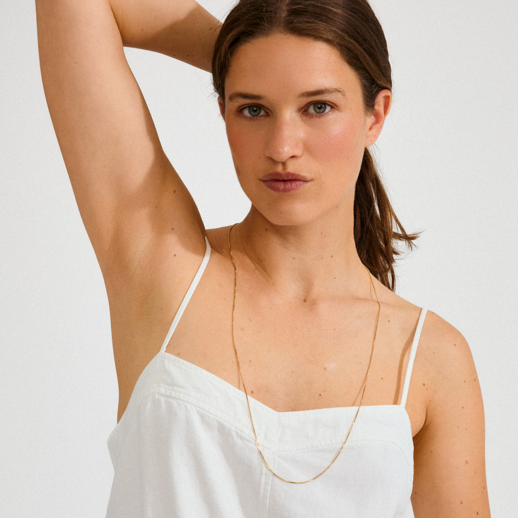 Young woman wearing the NANCY necklace, an 80 cm gold-plated chain, perfect for layering with charms and pendants.