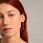 SANNE large hoop earrings, gold-plated, 45 mm, worn by a red-haired woman, showcasing timeless elegance and versatile style.