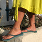 Person wearing a yellow dress and sandals, showcasing the PALLAS silver-plated anklet, a stylish accessory perfect for summer or festive occasions.