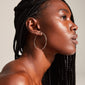 SANNE X-large silver-plated hoop earrings showcased on a woman, highlighting the sleek design and classy, feminine look of these 60 mm statement pieces.