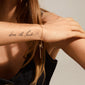 Close-up of a woman wearing the PERI twirl bracelet, a gold-plated, delicately twisted band, showcasing timeless Scandinavian design.