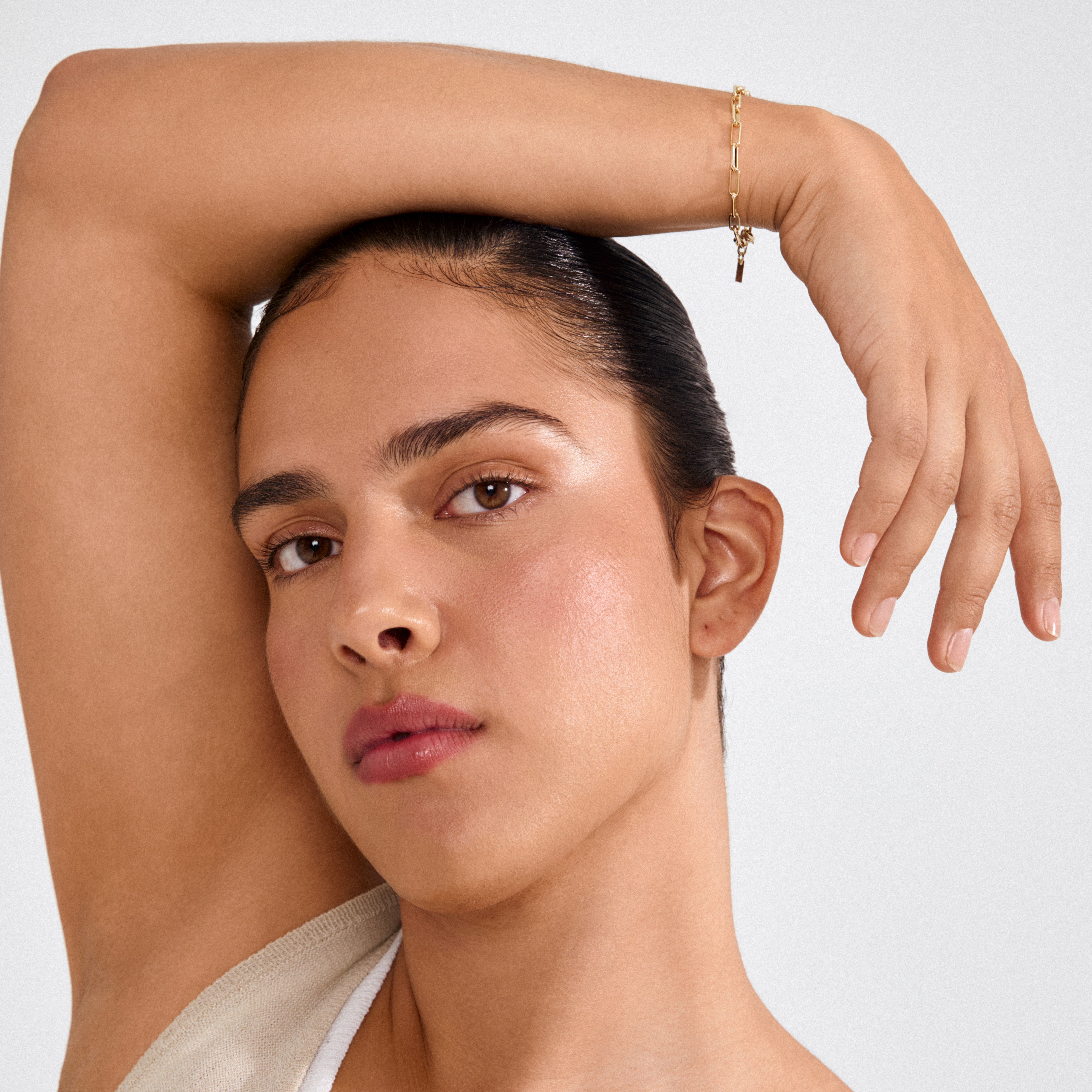 Close-up of a person wearing the RONJA gold-plated bracelet, showcasing its sleek rectangular links on their wrist, with a focus on effortless, contemporary style.