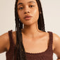 PERI twirl necklace gold-plated displayed on a woman with braided hair, showcasing its delicate, twisted design that embodies timeless femininity and simplicity.