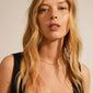 Close-up of a woman wearing the gold-plated Pam necklace with a chunky, twisted cord chain, highlighting its elegant design.