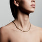 Close-up of a woman wearing the FUCHSIA gold-plated curb chain necklace, showcasing its chunky, bold design.