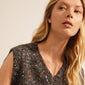 Woman wearing the PERI twirl necklace, a silver-plated piece with intricate twists, enhancing her simple sweater look with a minimalist, feminine touch.