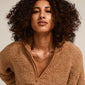 A woman wearing the RONJA silver-plated necklace, featuring rectangular links for a modern, versatile style, complementing her curly hair and brown sweater.