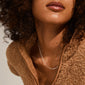 Woman with curly hair wearing a brown jacket, showcasing the RONJA necklace silver-plated with rectangular links, highlighting its modern, versatile design.