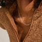 Close-up of a person wearing the RONJA necklace silver-plated, featuring sleek rectangular links around the neck, paired with a partially unzipped teddy-fleece jacket.