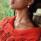 Woman wearing the PAM robe chain necklace, silver-plated with twisted details, paired with earrings. The necklace features a unique design for layering.