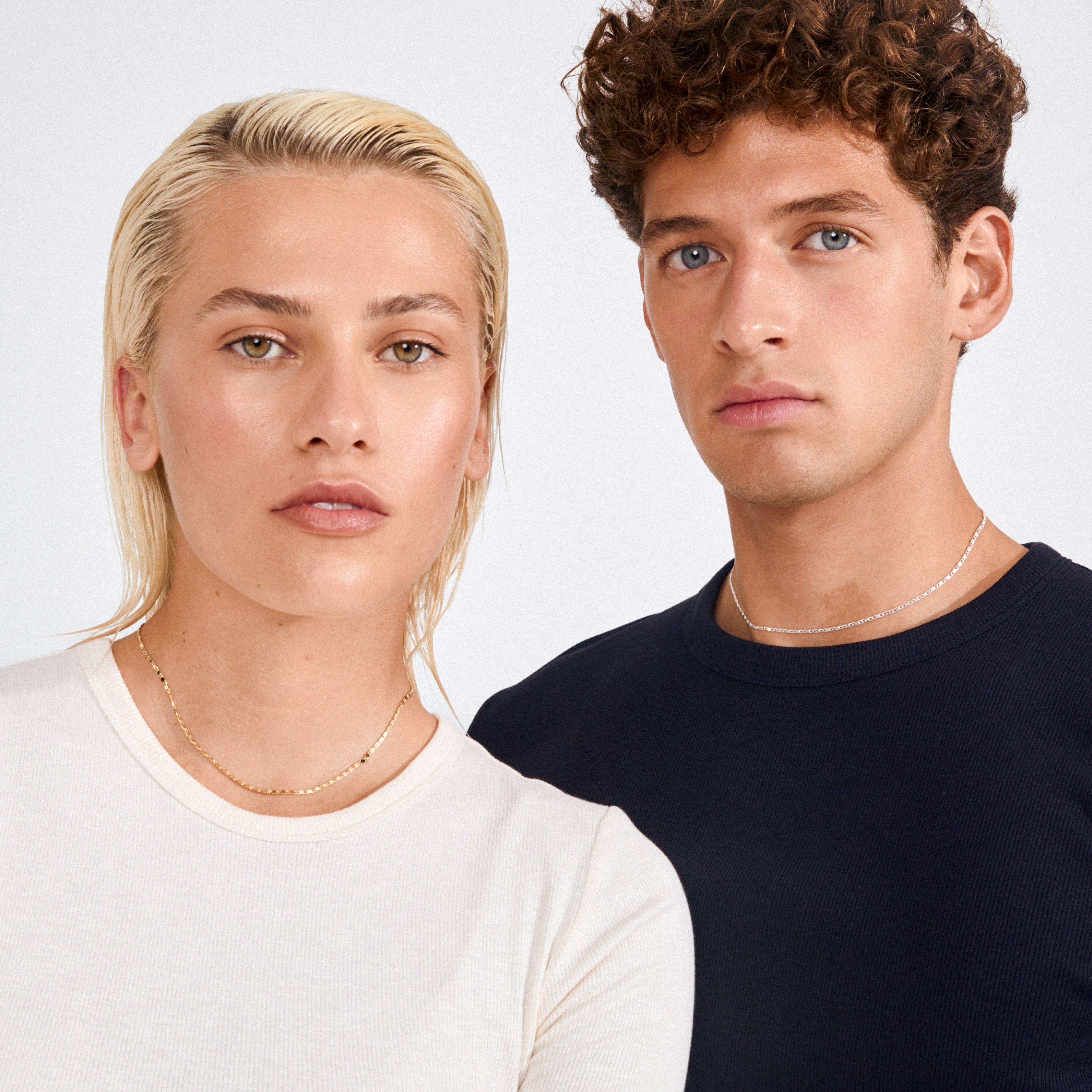 Young man wears the PARISA flat link chain necklace, silver-plated, showcasing its reflective, polished links for a chic, layered style.