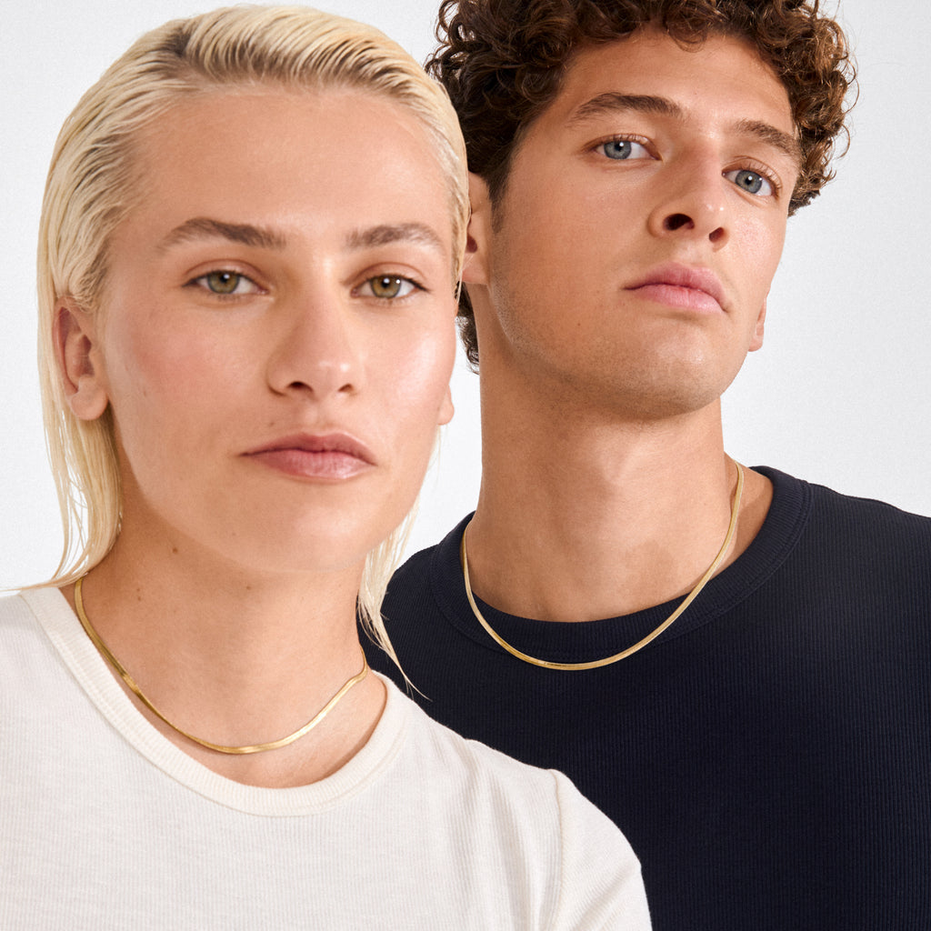 Models showcase the JOANNA gold-plated flat snake chain necklace, emphasizing its sleek, minimalist design and recycled material craftsmanship from Pilgrim’s Classics collection.