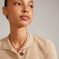 JOANNA flat snake chain necklace, rose gold-plated, worn by a woman looking sideways, showcasing its urban-inspired design and feminine elegance.
