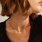 JOANNA flat snake chain necklace, rose gold-plated, elegantly adorns a woman's neck, showcasing its urban-inspired design with a feminine twist.