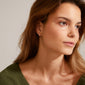 JOANNA snake chain hoop earrings, rose gold-plated, worn by a woman looking sideways, showcasing their urban-inspired design and interlocking chain structure.