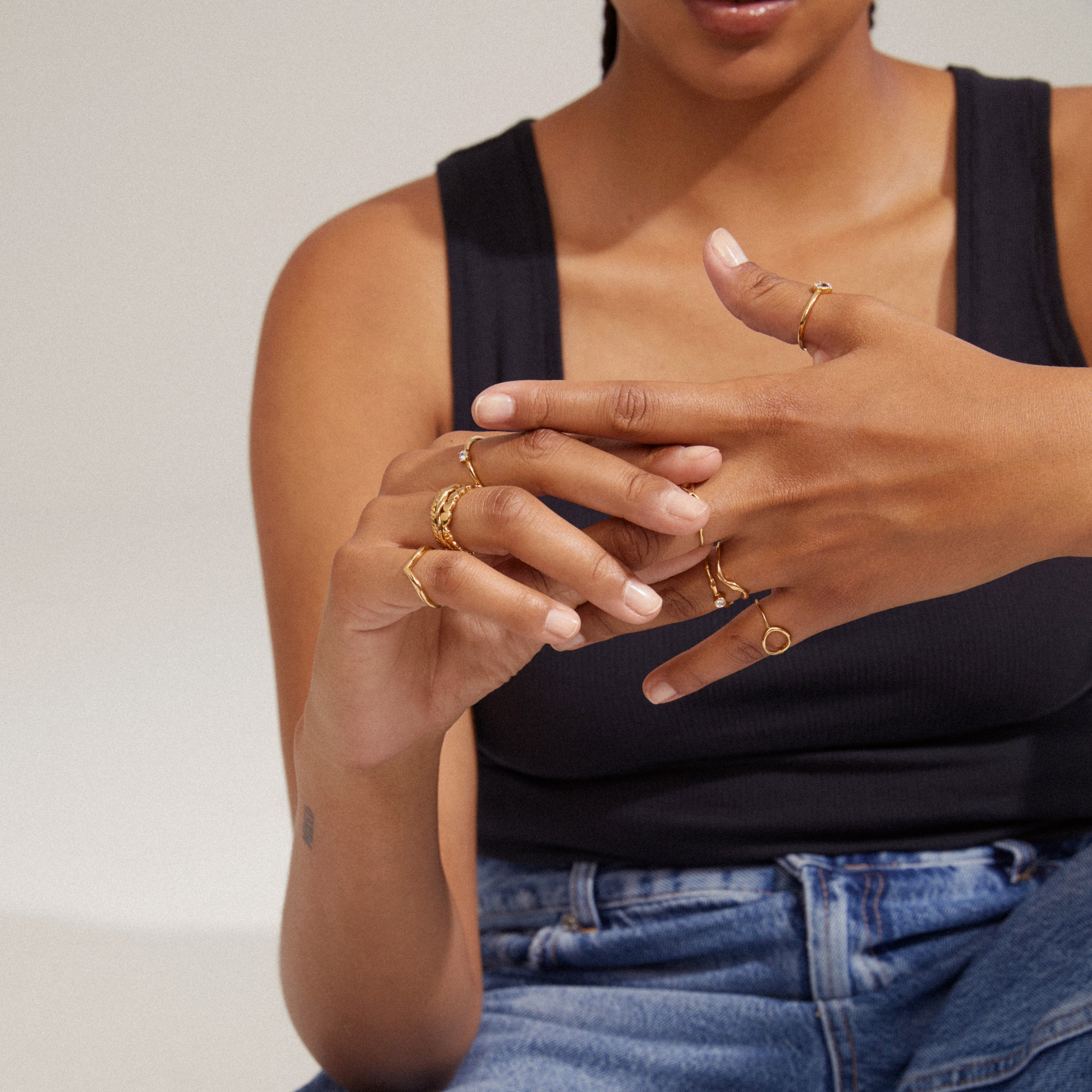 LULU crystal stack ring gold-plated on woman's hand, showcasing its slim, shiny design with a sparkling Preciosa crystal, ideal for stacking and layering.