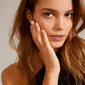 Close-up of a woman wearing the LULU stack ring gold-plated, featuring an asymmetrical design reminiscent of hearts or stones, perfect for stacking.