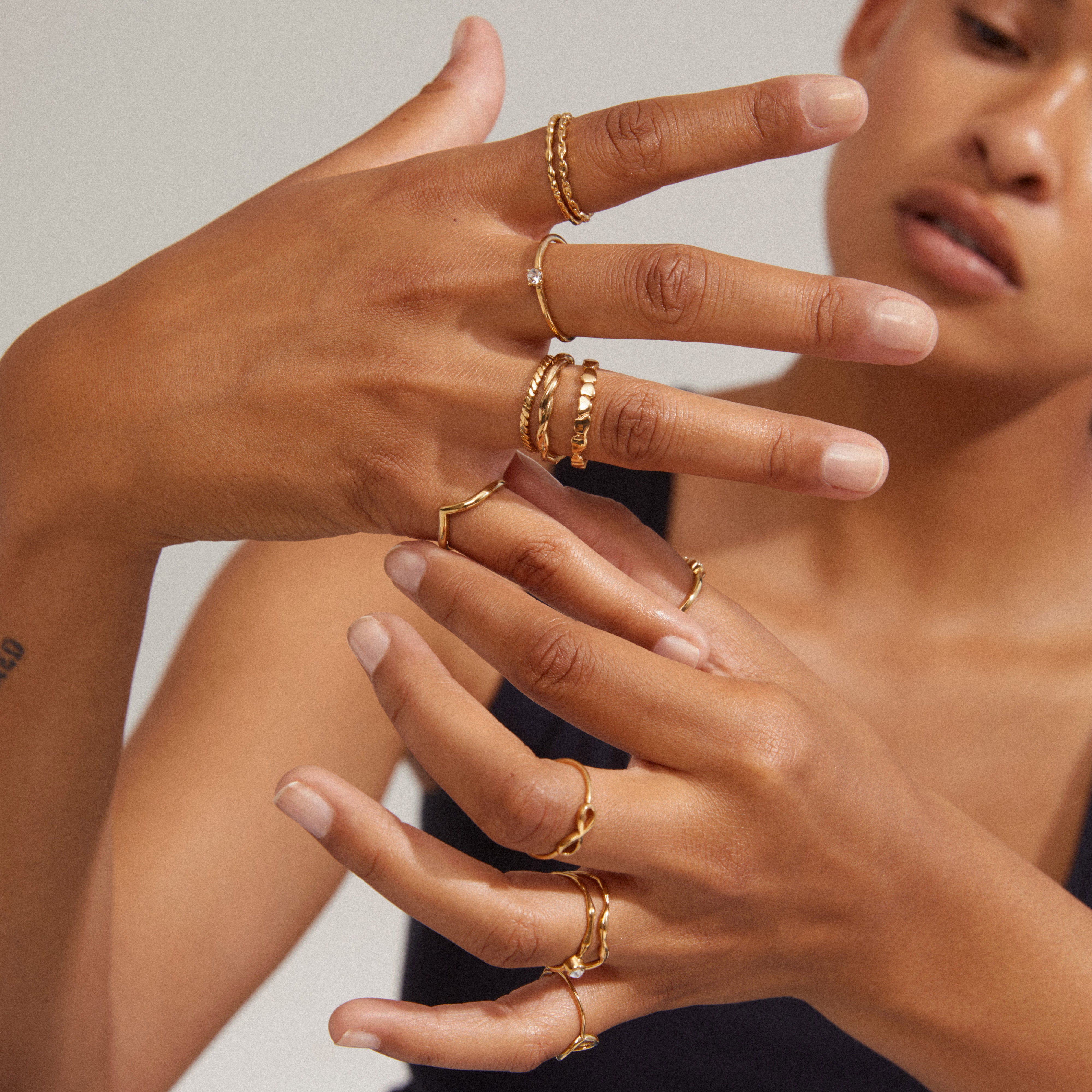 Close-up of a woman's hand wearing the LULU crystal heart stack ring, gold-plated, from Pilgrim's Lulu collection, highlighting its elegant and stackable design.