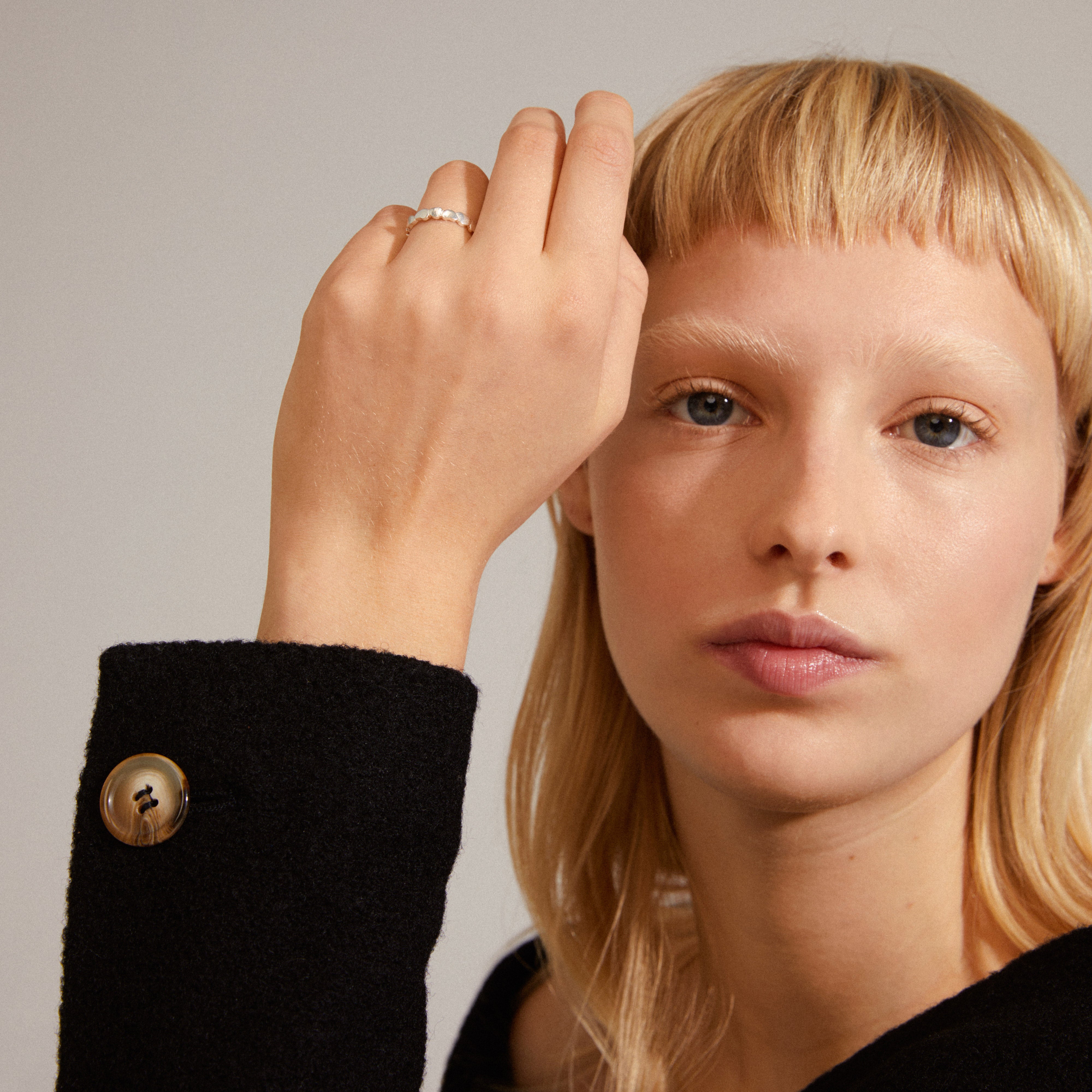 Woman wearing LULU stack ring, silver-plated with organic shapes, on her finger, showcasing Pilgrim's blend of timeless and trendy Danish design.