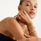 Close-up of a woman's wrist adorned with the RANI bracelet, a gold-plated, recycled piece with organically shaped links from Pilgrim's collection.